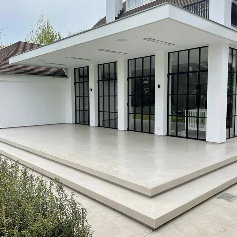 Limestone ivory microcement covered loggia terrace in Park City, Utah with stepped edge detail and black steel Crittall doors