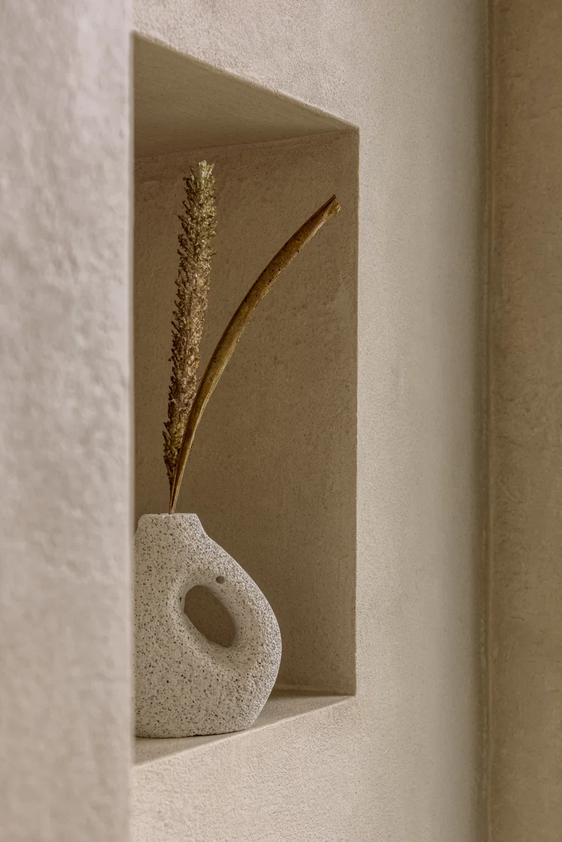 Warm sand oat textured microcement wall with recessed display niche detail in Park City, Utah showing grainy artisanal hand-applied surface and wabi-sabi tactility