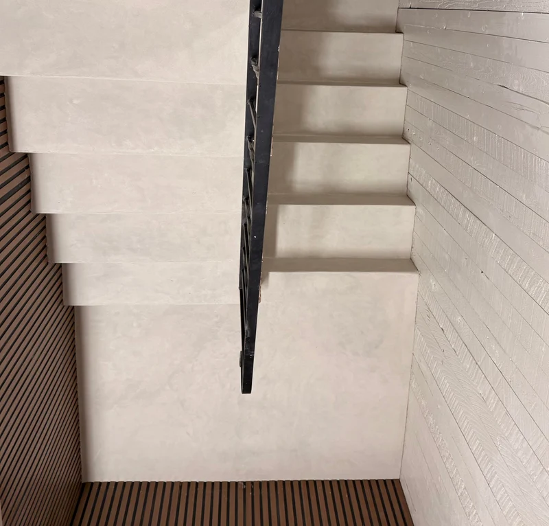 Alabaster greige microcement floating staircase in Park City, Utah with black steel stringer and whitewashed timber cladding