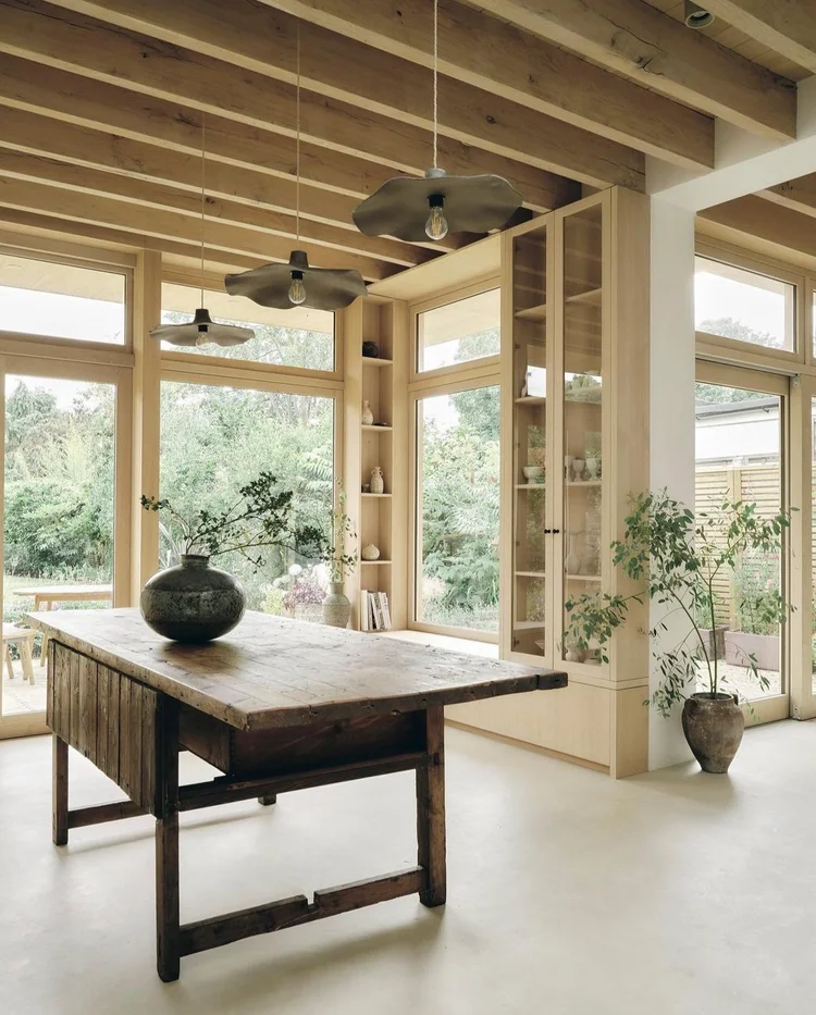 Bone ivory microcement open-plan kitchen and dining floor in Park City, Utah with exposed oak beams and antique refectory table