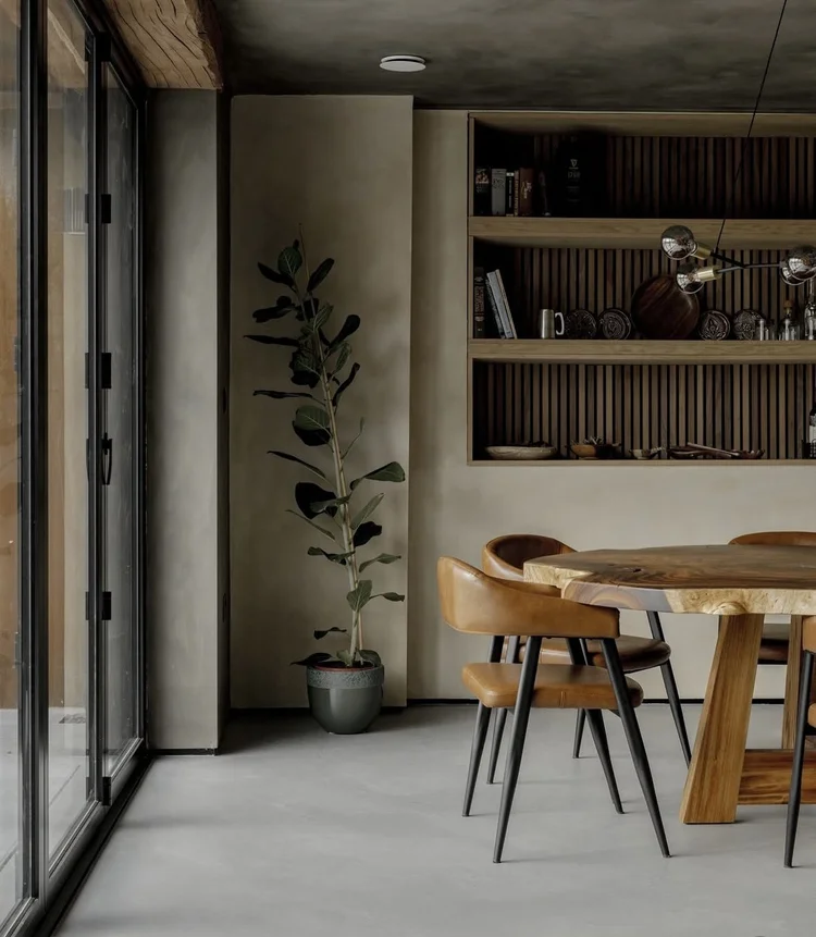 Olive khaki putty microcement dining room walls in Park City, Utah with charcoal ceiling, recessed fluted shelving, black steel Crittall glazing and tan leather