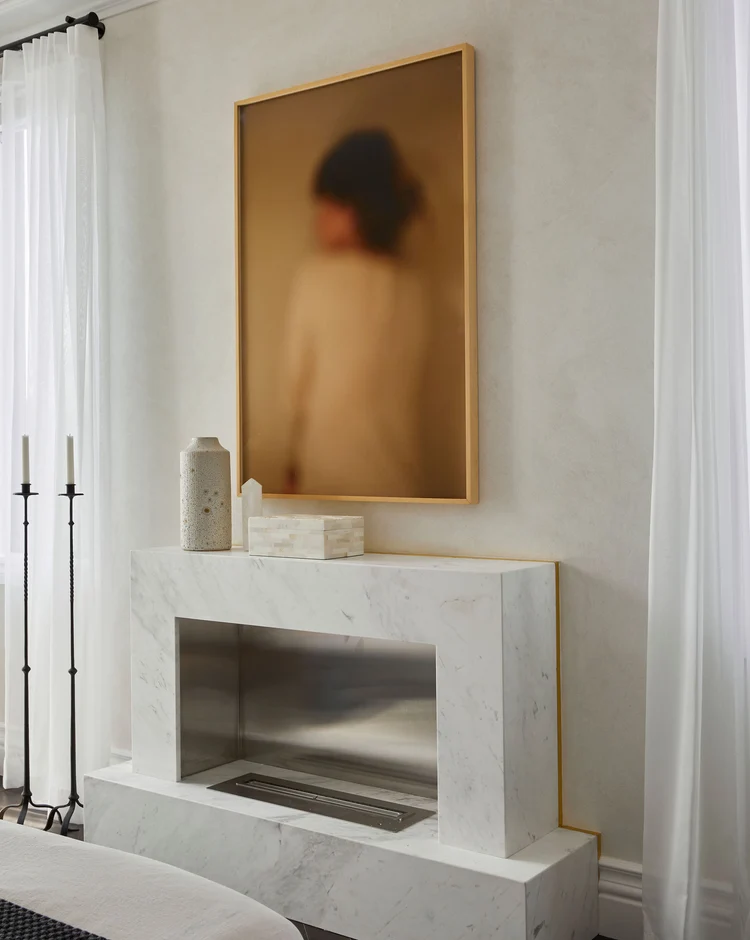 Soft oyster white microcement bedroom feature wall in Park City, Utah with cloudy tonal movement, marble fireplace surround, brass reveal and sheer curtains